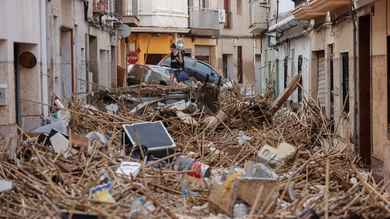 Una mujer camina tras la dana entre los escombros acumulados en una calle de Paiporta, Valencia, el 30 de octubre de 2024